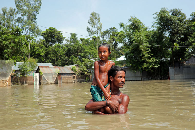 Flood-affected people wade through flooded water in Jamalpur, Bangladesh, on 21 July 2019. Photo: Reuters