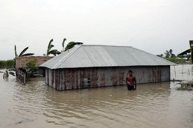 A man stands near a flooded house in Jamalpur, Bangladesh, on 22 July 2019. Photo: Reuters