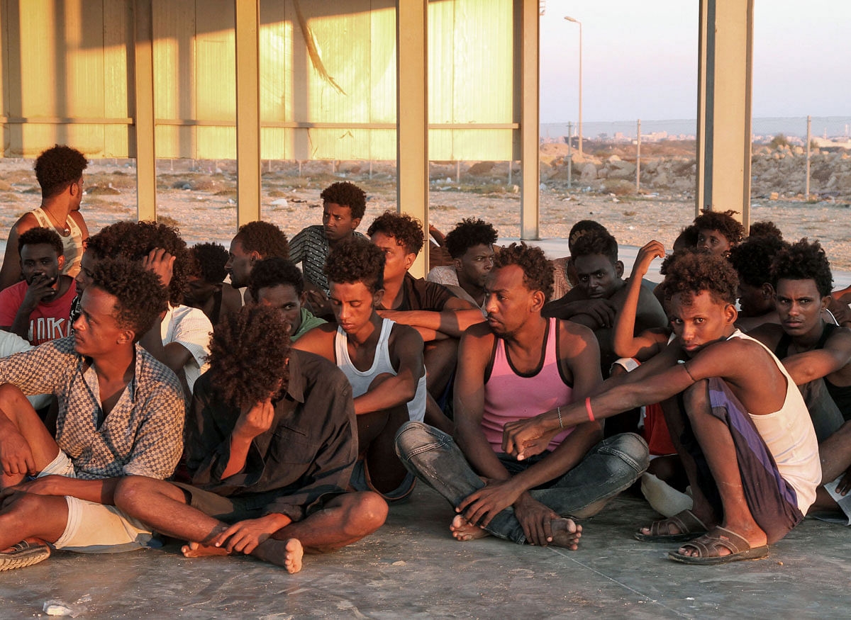 Rescued migrants sit on the coast of Khoms, some 100 kilometres (60 miles) from Tripoli, on 26 July 2019. Photo: AFP