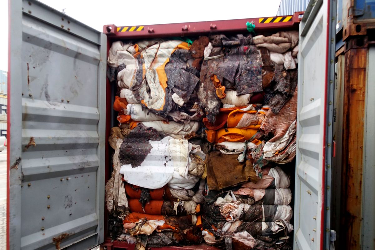 This handout picture provided by Sri Lankan Customs on 23 July 2019, shows the load of a container being inspected by customs officials at a port in Colombo. Sri Lanka customs on 23 July ordered the return of container loads of hazardous mortuary and clinical waste illegally imported into the island from Britain. Photo: AFP
