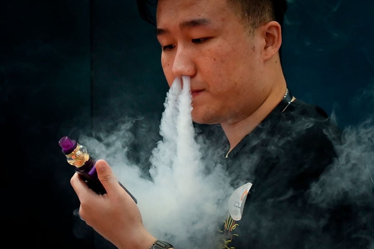 This file photo taken on 28 June 2019 shows a promoter of an e-cigarette company smoking an electronic cigarette at the Beijing International Consumer Electronics Expo. Photo: AFP