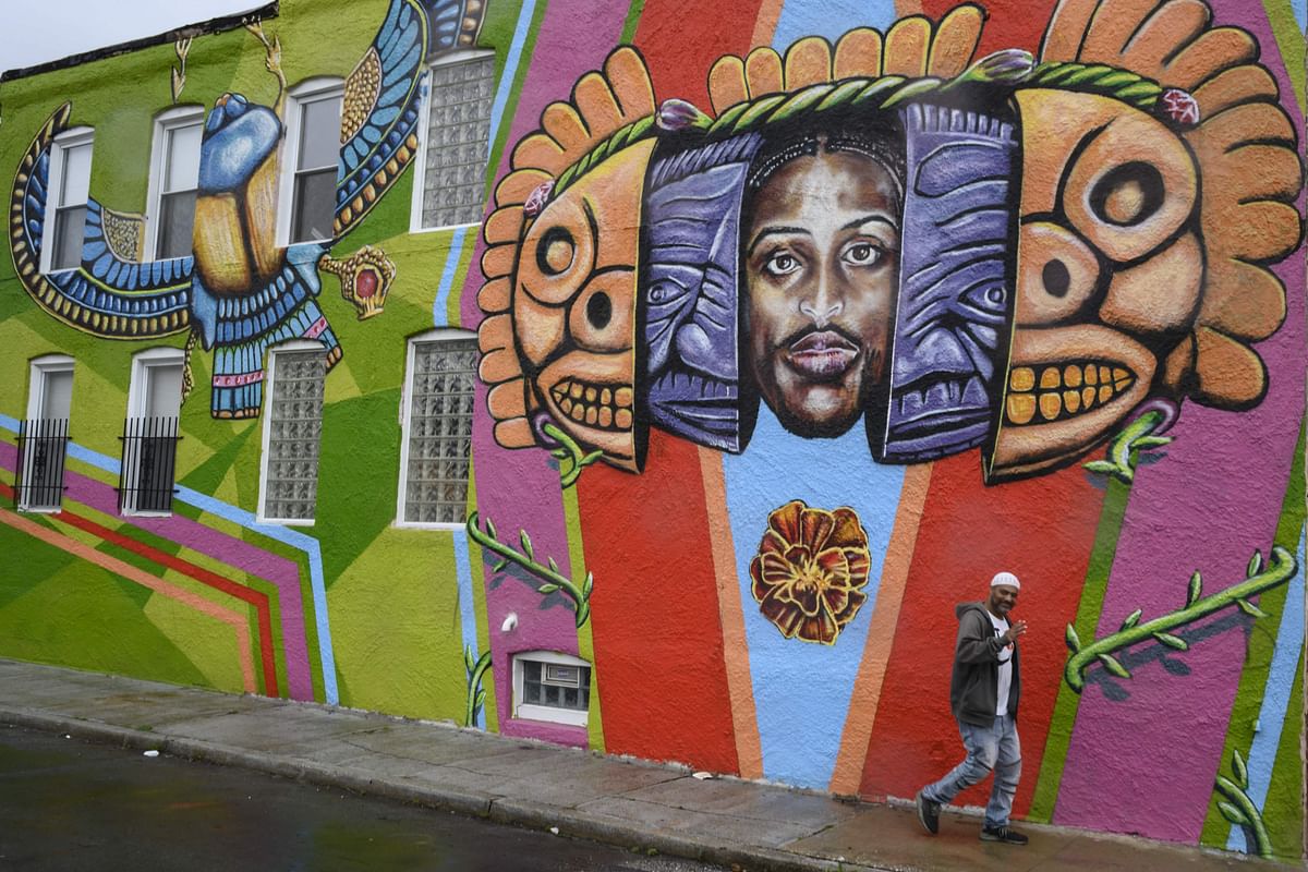 In this file photo taken on 12 April 2019, a man walks by a mural painting on a rainy day in the McElderry Park area in Baltimore, Maryland. Photo: AFP