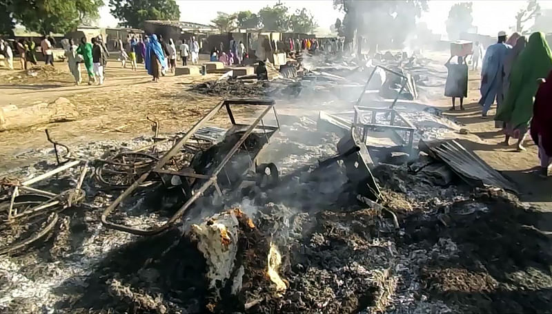 Smoldering ashes and charred items are seen on the ground in Budu near Maiduguri on 28 July 2019, after the latest attack by Boko Haram fighters on a funeral in northeast Nigeria has left 65 people dead. Photo: AFP