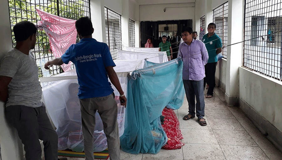 Dengue infected people are kept in mosquito curtain on floor due to shortage of space. Photo: UNB