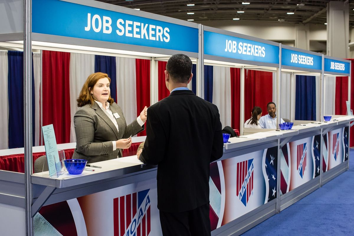 In this file photo taken on 24 April 2012, Elizabeth Fahey (L) talks with a job seeker at the Military Officers Association of America career fair in Washington, DC. Photo: AFP