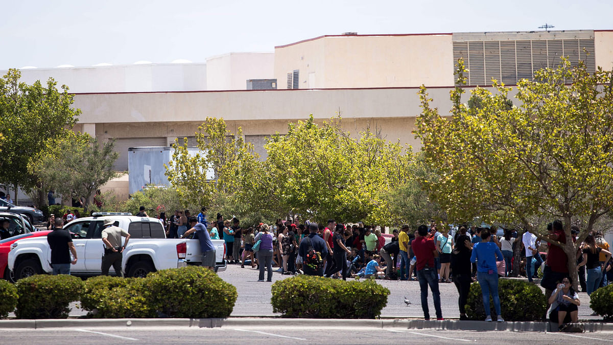 Individuals that were evacuated sit in a parking lot across from a Wal-Mart where a shooting occurred at Cielo Vista Mall in El Paso, Texas, Saturday, on 3 August 2019. Photo: AFP