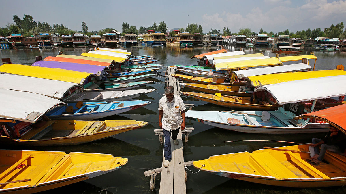 A boatman walks past the parked `Shikaras` or boats for tourists on the banks of Dal Lake in Srinagar 4 August, 2019. Photo: Reuters.