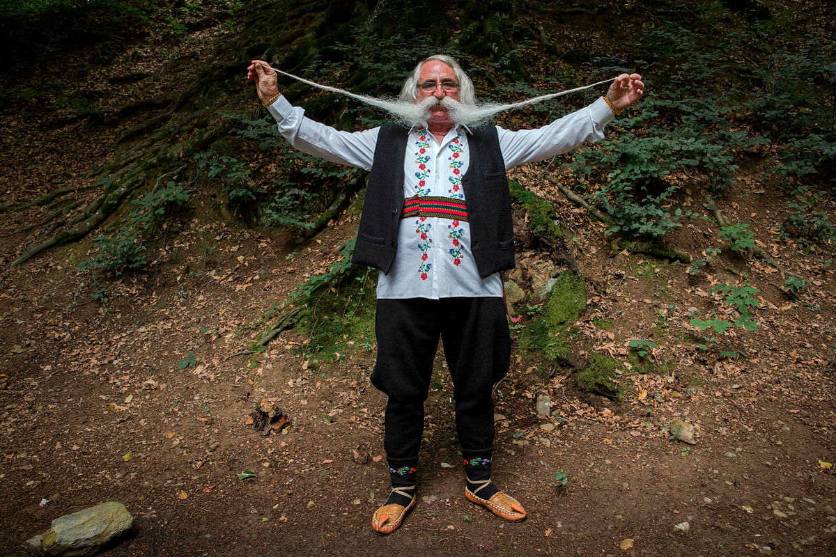 Zoran Lazarevic, 70-years-old, shows off his moustache as he takes part in the longest moustache competition at the 15th century Kalenic Serbian Orthodox monastery, near Rekovac, central Serbia on 4 August 2019. Lazarevic won the competition with his 140 centimetre long moustache. Photo: AFP