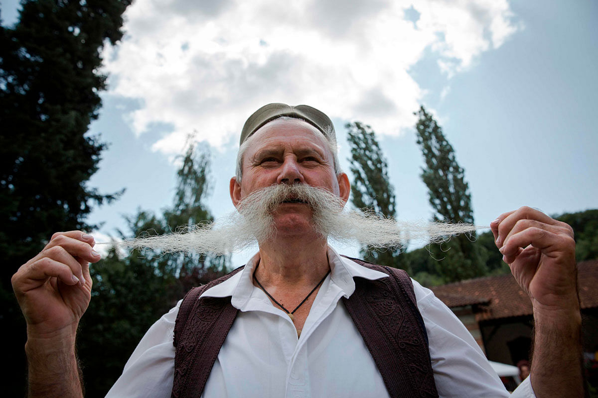 A participant in the longest moustache competition poses at the 15th century Kalenic Serbian Orthodox monastery, near Rekovac, central Serbia on 4 August 2019. Photo: AFP
