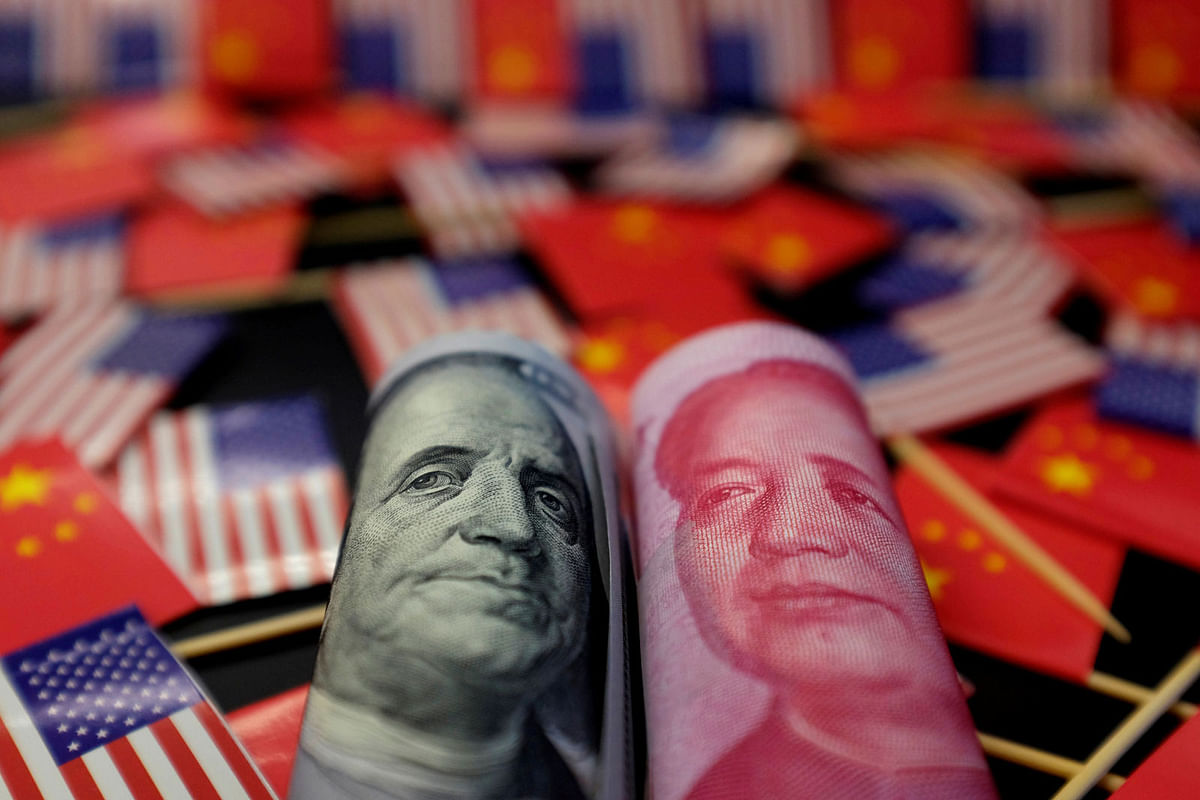 A US dollar banknote featuring American founding father Benjamin Franklin and a China`s yuan banknote featuring late Chinese chairman Mao Zedong are seen among US and Chinese flags in this illustration picture taken 20 May. Photo: Reuters
