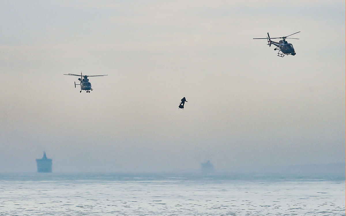 Franky Zapata stands on his jet-powered `flyboard` next to helicopters as he arrives at St. Margaret`s Bay in Dover, on 4 August 2019, during his attemp to fly across the 35-kilometre (22-mile) Channel crossing in 20 minutes, while keeping an average speed of 140 kilometres an hour (87 mph) at a height of 15-20 metres (50-65 feet) above the sea. Photo: AFP