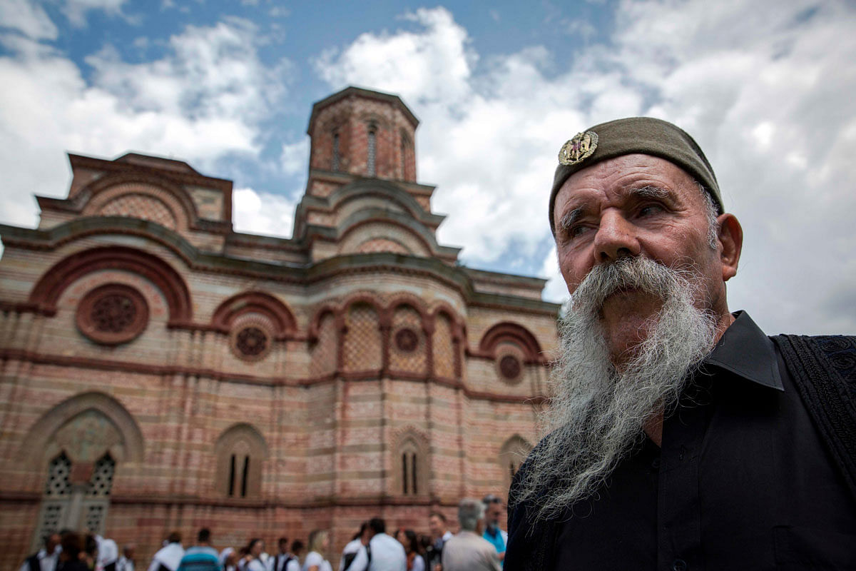 A participant in the longest moustache competition poses outside of the 15th century Kalenic Serbian Orthodox monastery, near Rekovac, central Serbia on 4 August 2019. Photo: AFP