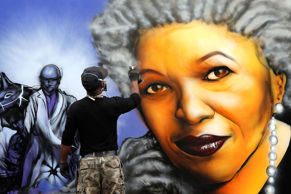 An artist completes a wall painting depicting Nobel-winning US novelist Morrison at a ceremony of a memorial bench marking the abolition of slavery in Paris. Photo: Reuters