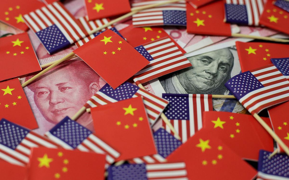 A US dollar banknote featuring American founding father Benjamin Franklin and a China’s yuan banknote featuring late Chinese chairman Mao Zedong are seen among US and Chinese flags in this illustration picture taken 20 May. Picture taken on 20 May. Photo: Reuters