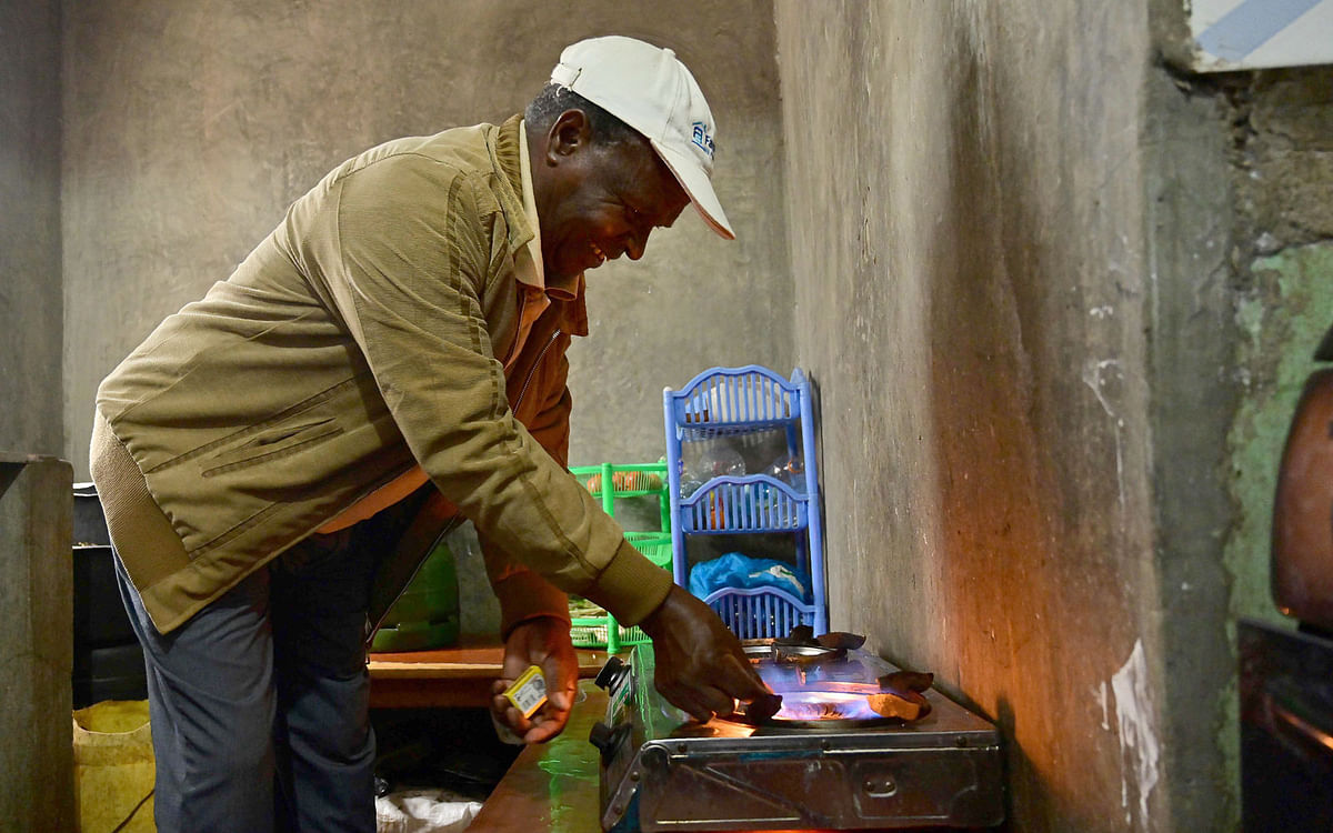 Kenyan farmer, Josphat Muchiri lights his biogas burner at his coffee plantation in Kiambu county, on 2 August. Photo: AFP