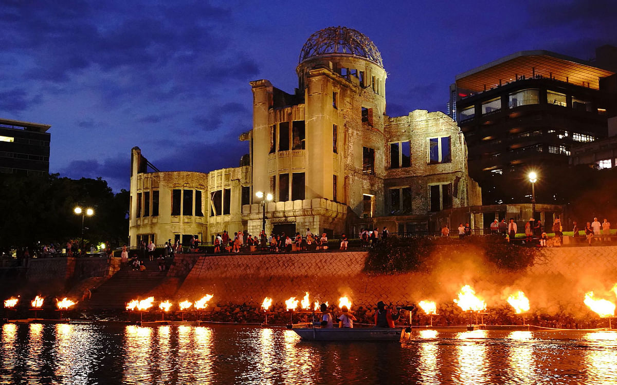 This 5 August 2019 picture shows people standing next to the atomic bomb dome at the Peace Memorial Park in Hiroshima, one day before the 74th anniversary of atomic bombing in Hiroshima. Photo: AFP