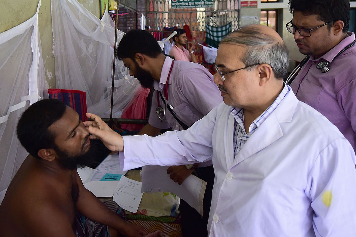 This photograph taken on 4 August 2019, shows that A Bangladeshi doctor inspects a man who is suffering from dengue fever in the `Shaheed Suhrawardy` Medical Colleague Hospital in Dhaka. Bangladesh is in the grip of the country`s worst-ever dengue fever outbreak, with hospitals overflowing and social media flooded with pleas for blood donors. Photo: AFP
