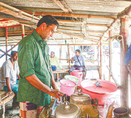 Union Parishad member Baharul Islam busy working at his tea stall. Photo:  Chhutir Dine