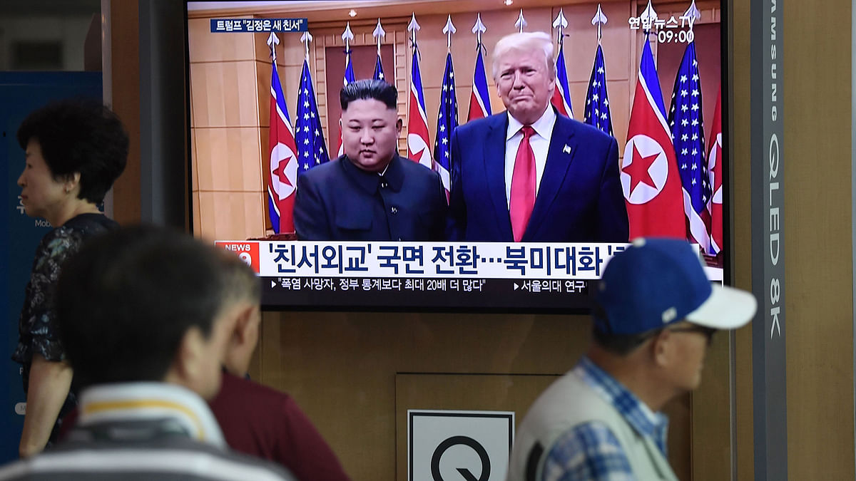 People watch a television news screen showing file footage of a meeting between US president Donald Trump and North Korean leader Kim Jong Un which was held at the truce village of Panmunjom in the DMZ, at a railway station in Seoul on 10 August, 2019. Photo: AFP