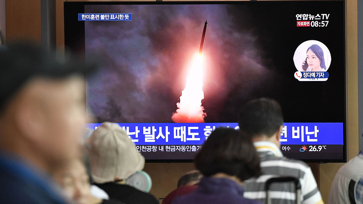 People watch a television news screen showing file footage of North Korea`s missile launch, at a railway station in Seoul on 10 August 2019. Photo: AFP