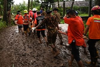 Rescue workers carry the body of a landslide victim in Paung township, Mon state on August 10, 2019. The death toll from a landslide triggered by monsoon rains in eastern Myanmar rose to at least 34, an official said on 10 August, as emergency workers continued a desperate search through thick mud for scores more feared missing. Photo: AFP