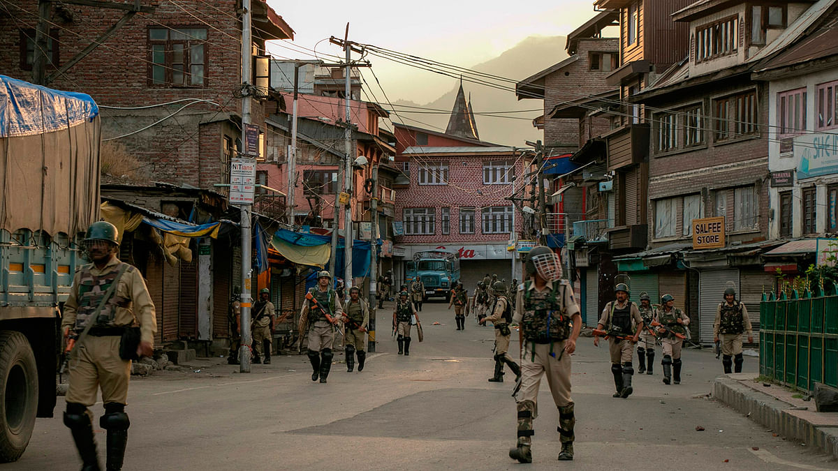 Indian security personnel walk on a street in Srinagar on 9 August 2019, as widespread restrictions on movement and a telecommunications blackout remained in place after the Indian government stripped Jammu and Kashmir of its autonomy. Photo: AFP