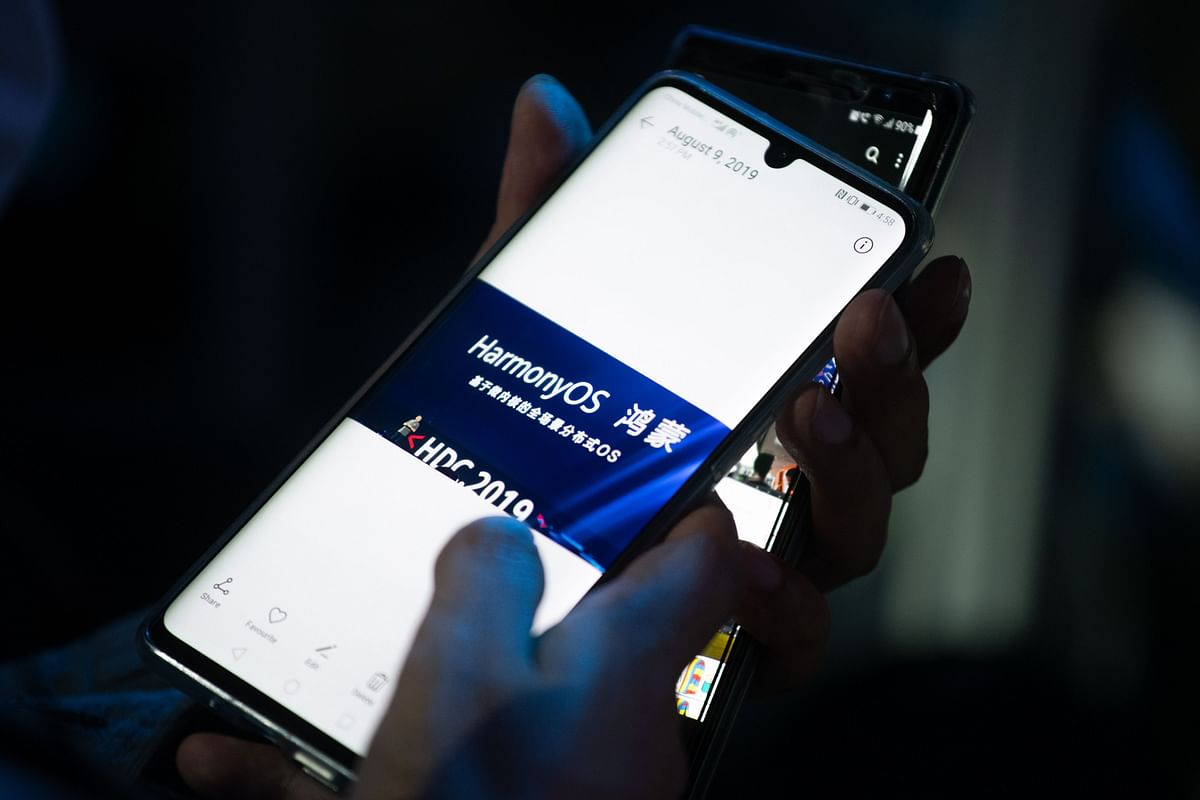 A guest holds her phone showing a picture taken during Huawei`s press conference unveiling its new HarmonyOS operating system in Dongguan, Guangdong province on 9 August, 2019. Photo: AFP