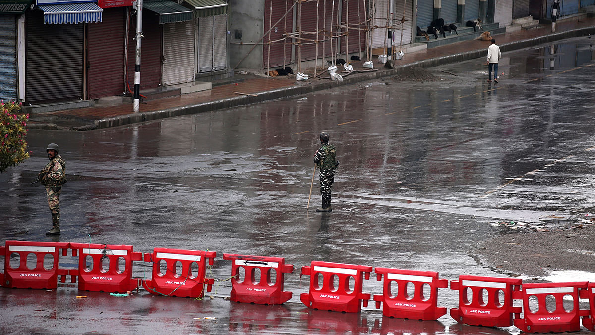 Indian security force personnel stand guard in a deserted street during restrictions after the government scrapped special status for Kashmir, in Srinagar on 8 August 2019. Photo: Reuters