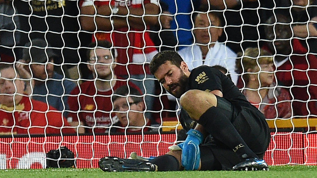 Liverpool`s Brazilian goalkeeper Alisson Becker waits to receive medical attention during the English Premier League football match between Liverpool and Norwich City at Anfield in Liverpool, north west England on 9 August 2019. Photo: AFP