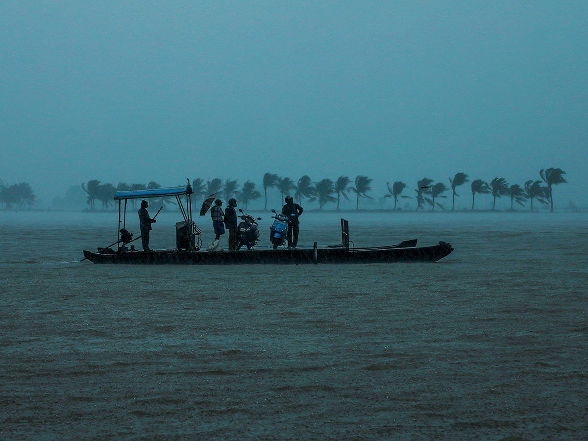 Residents are being evacuated from their home to a safer place following floods warnings, on a wooden boat at Kadamakkudi near Kochi in the Indian state of Kerala on 10 August 2019. Photo: AFP