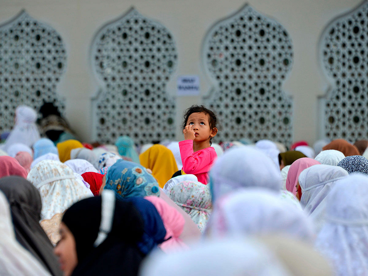 A child looks on while attending morning prayer celebrating the Eid-ul-Azha festival at the Baiturrahman mosque in Banda Aceh on 11 August 2019. Photo: AFP