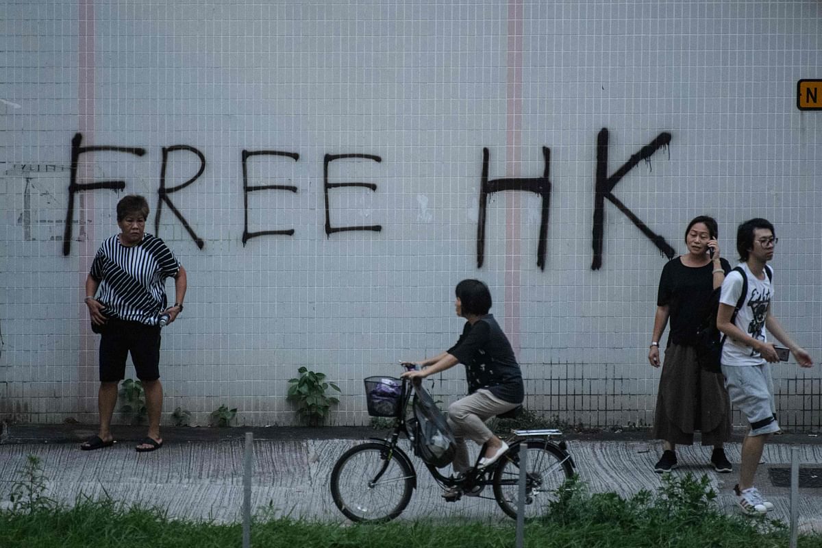 A cyclist rides past graffiti that reads `Free HK` in the Tai Wai area of Hong Kong on 10 August as protesters take part in demonstrations against a controversial extradition bill. Photo: AFP