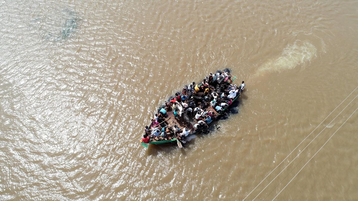 An aerial view of locals being rescued on a boat in waterlogged Jamkhandi Taluk at Belgaum district of Karnataka state situated about 525 kms north of the south Indian city of Bangalore on 11 August 2019. Photo: AFP