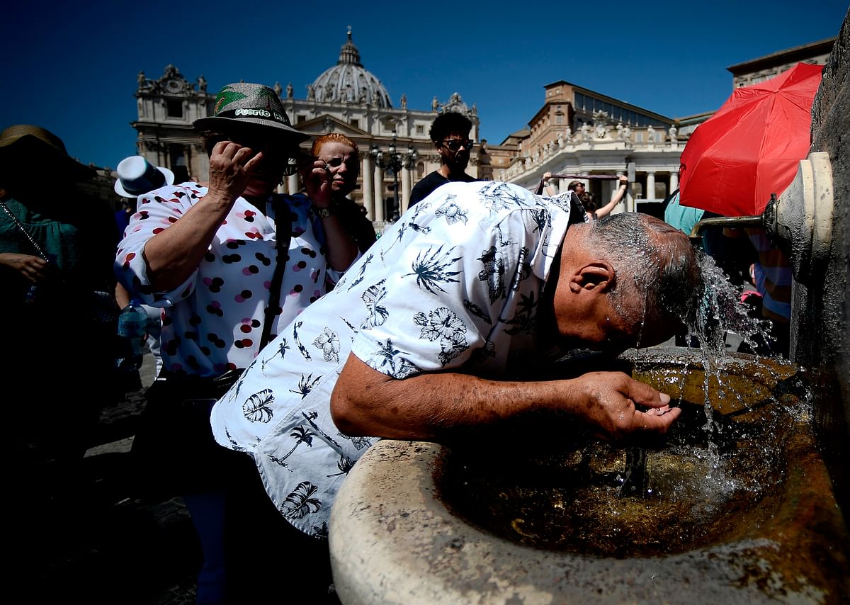 Pilgrims refresh themselves in a fountain in St. Peter`s Square, at the Vatican, prior Pope Francis Sunday Angelus prayer on 11 August 2019. Photo: AFP
