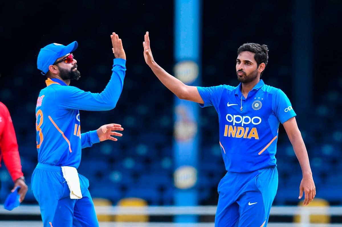 Virat Kohli (L) and Bhuvneshwar Kumar (R) of India celebrate the dismissal of Chris Gayle of West Indies during the 2nd ODI match at Queens Park Oval in Port of Spain, Trinidad and Tobago, on 11 August 2019. Photo: AFP