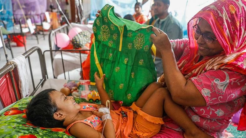 2 year and 9 month-old girl Ariba, hospitalised in a Dhaka hospital with dengue fever, expresses her joy after getting her Eid dress on 12 August, 2019. Photo: Dipu Malakar