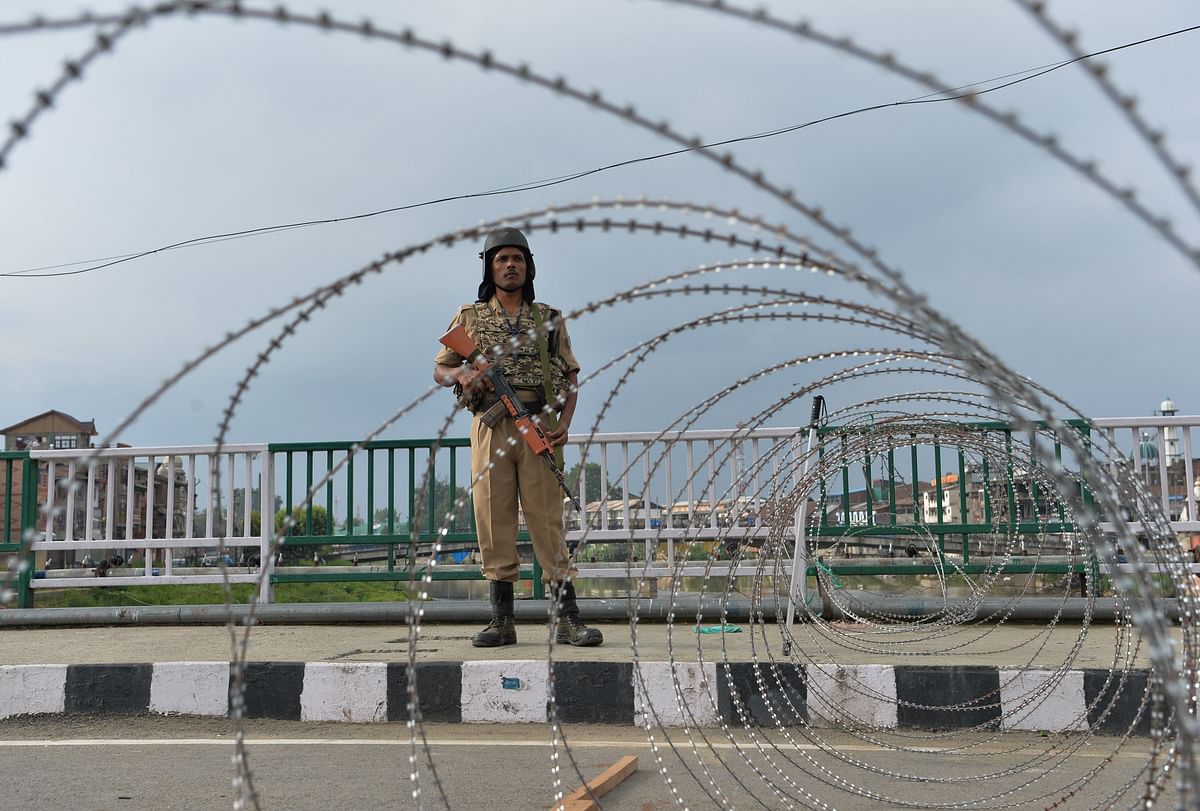 A security personnel stands guard on a street during a lockdown in Srinagar on 11 August 2019, after the Indian government stripped Jammu and Kashmir of its autonomy. Photo: AFP