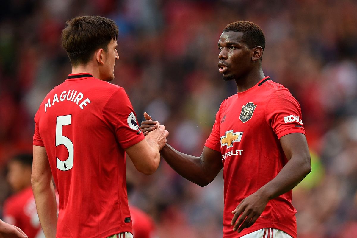 Manchester United`s English defender Harry Maguire (L) shakes hands with Manchester United`s French midfielder Paul Pogba (R) on the pitch at the final whistle in the English Premier League football match between Manchester United and Chelsea at Old Trafford in Manchester, north west England, on 11 August 2019. Photo: AFP