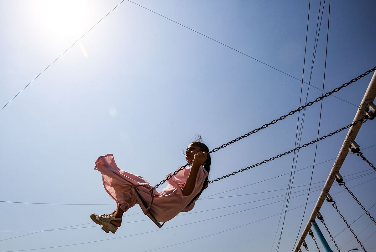 A girl rides on a swing in the Iraqi capital Baghdad`s eastern suburb of Sadr City, as people celebrate the Muslim religious festival of Eid al-Adha on 12 August 2019. Photo: AFP