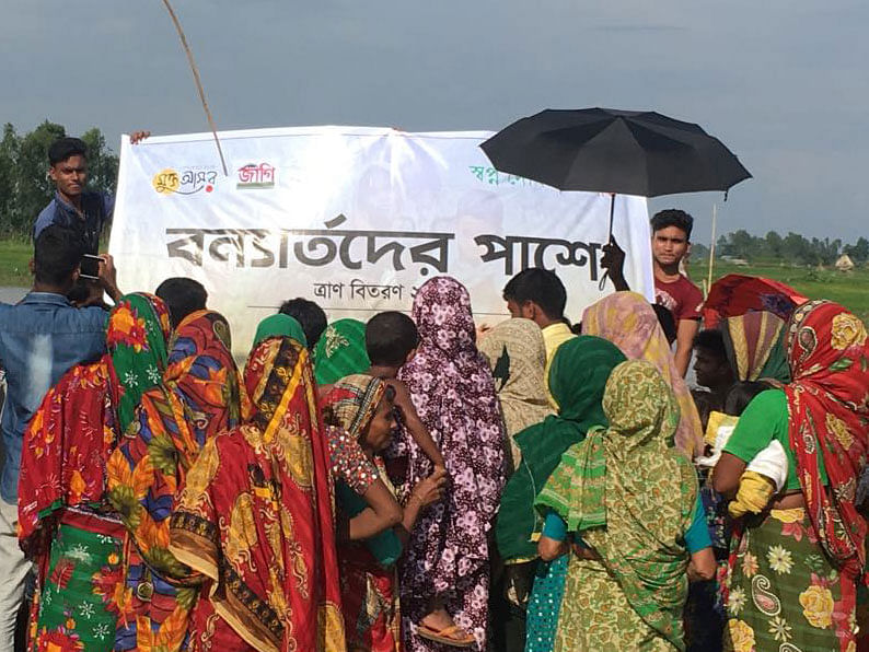 Members of Mukto Asor distribute relief materials among 200 flood-affected families of Kurigram recently. Photo: Prothom Alo