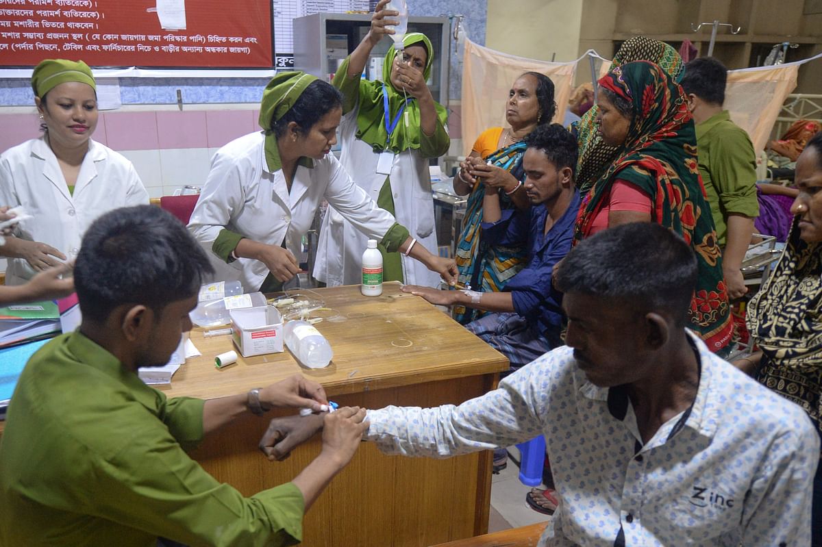 Bangladeshi medical assistants tend to patients suffering from dengue fever at the Mugda Medical College and Hospital in Dhaka on 8 August 2019. Photo: AFP
