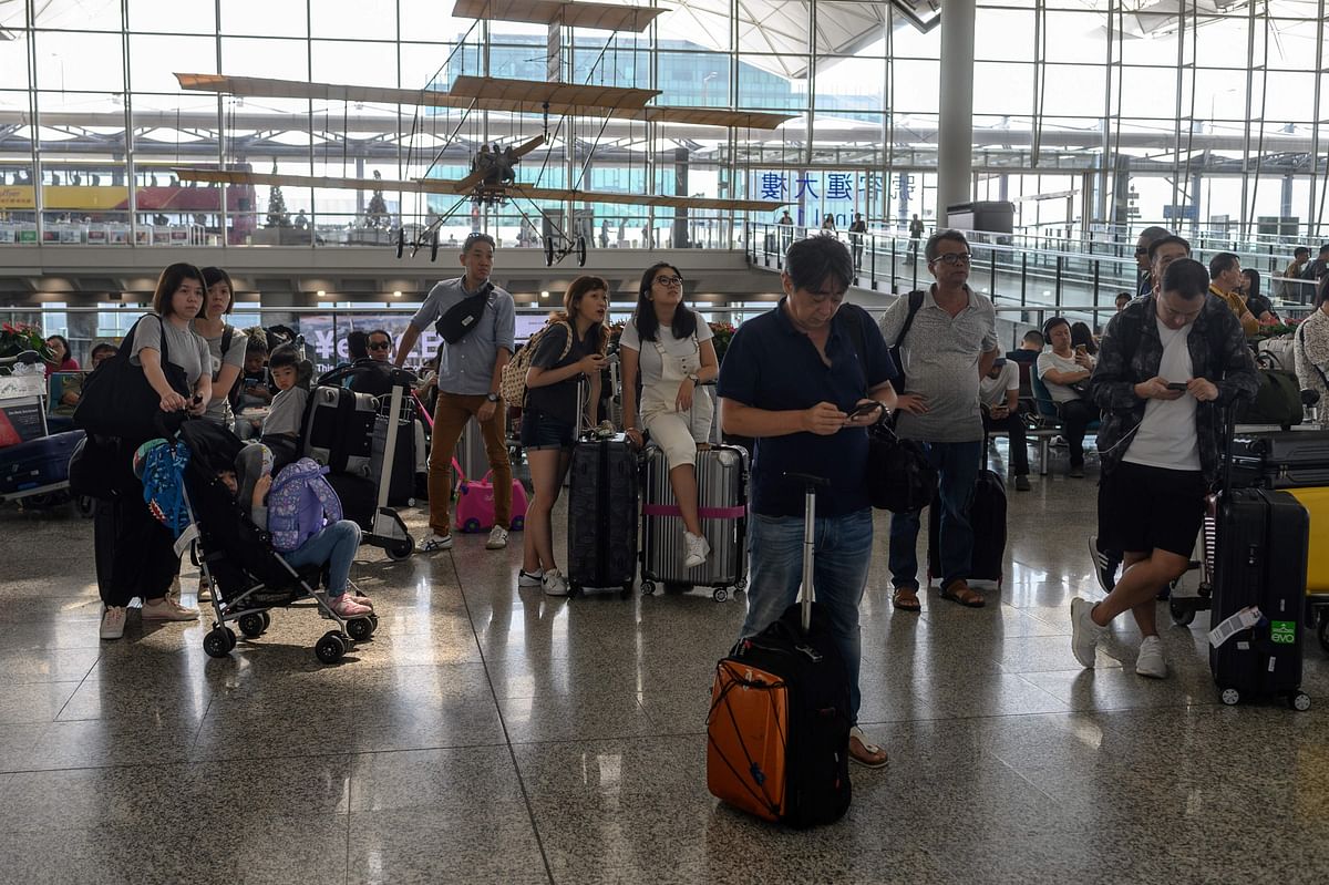 Passengers look at an electric board to check their flights status in the departures area of Hong Kong`s international airport on 13 August the day after the airport closed due to pro-democracy protests. Photo: AFP