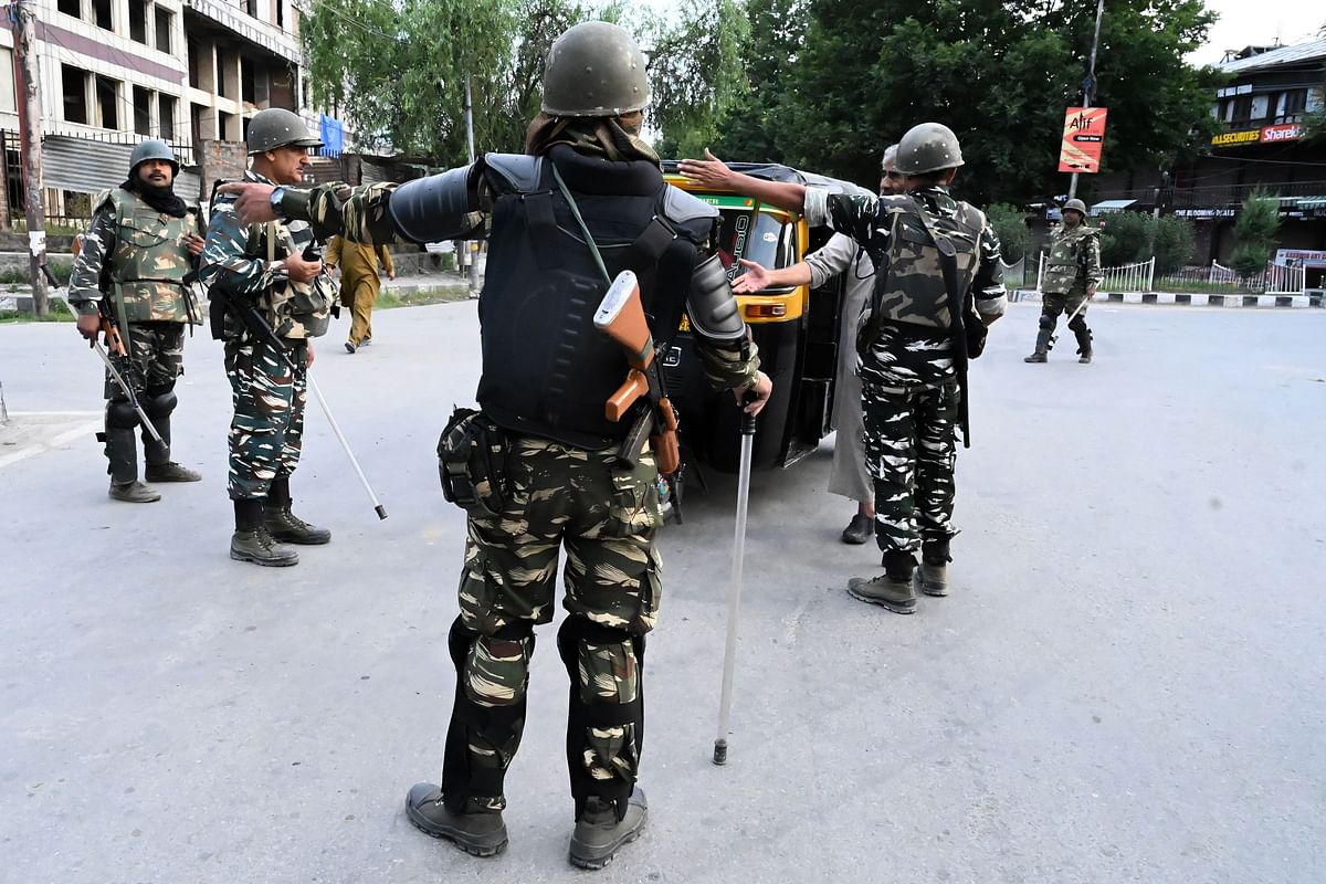 Security personnel stop an auto-rickshaw for questioning at a roadblock during a lockdown in Srinagar on 12 August 2019. Photo: AFP