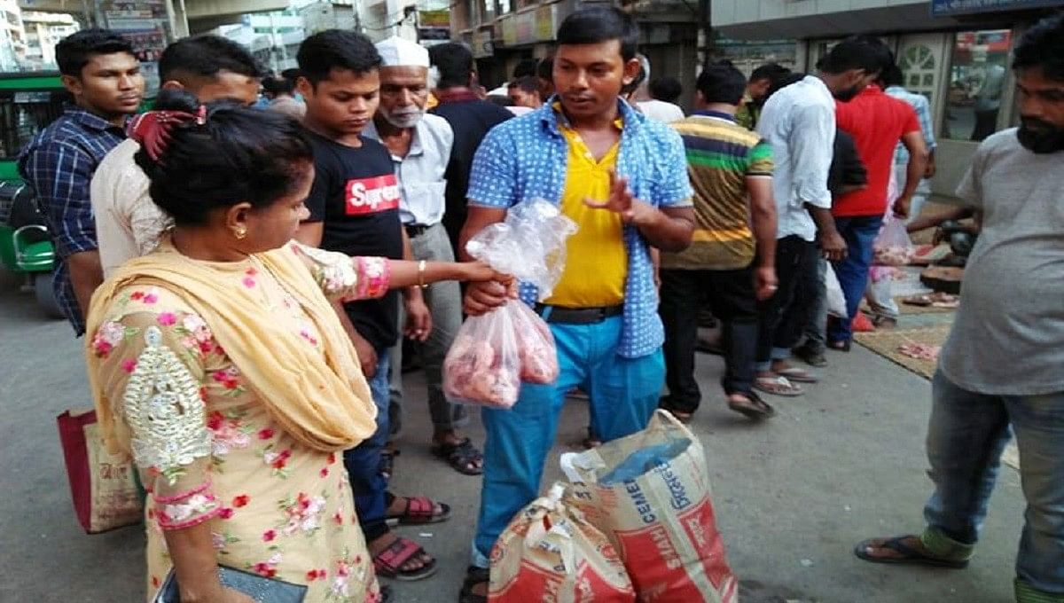 A woman buys beef cheaply at a makeshift meat market at Malibagh railway crossing, Dhaka on Monday. Photo: UNB