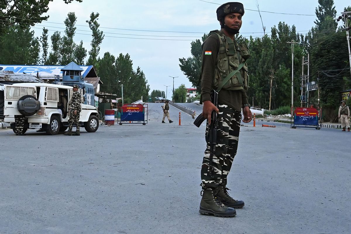 Security personnel stand guard a street during a lockdown in Srinagar on 12 August 2019. Photo: AFP