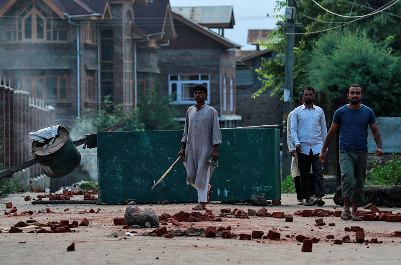 Kashmiris walk past a blockade put up by residents to prevent security personnel from sealing a mosque ground ahead of the Eid-al-Azha prayers during restrictions after the scrapping of the special constitutional status for Kashmir by the Indian government, in Srinagar, on 12 August 2019. Photo: Reuters