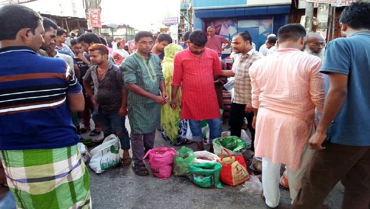 Many people gather at a makeshift meat market at Malibagh rail crossing, Dhaka on Monday to buy beef at a low price. Photo: UNB