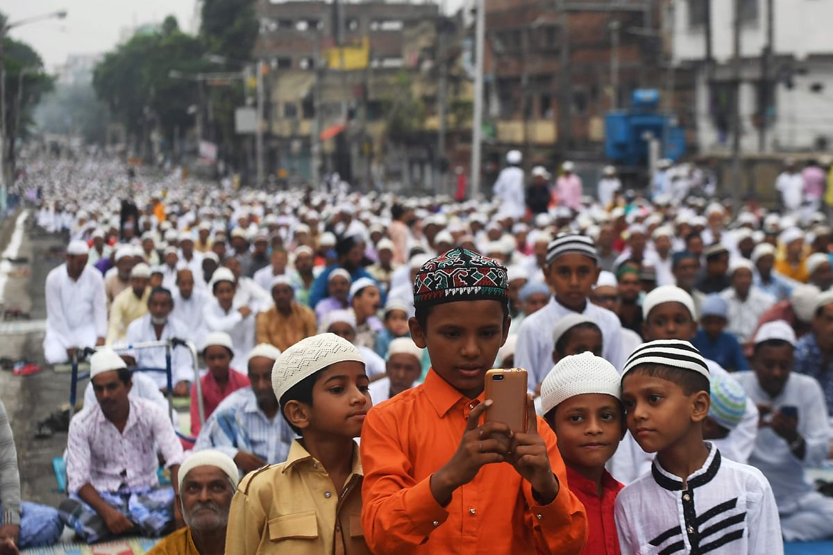 Young Muslims gather around a smartphone after participating in a special prayer organised to celebrate Eid al-Adha in Kolkata on 12 August 2019. Photo: AFP
