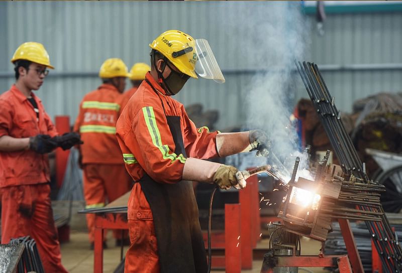 This file photo taken on 15 May 2019 shows Chinese employees working on rebars at a factory in Hangzhou, China`s eastern Zhejiang province. China`s economy showed signs of strain in July with output at its factories falling to its lowest level in 17 years, while investment and retail sales slowed, official data showed on 14 August 2019. Photo: AFP