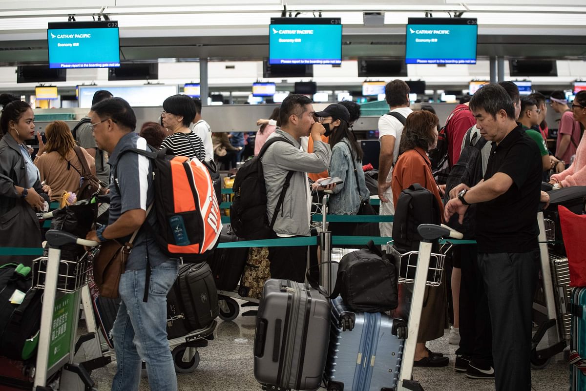 Passengers wait in line at check-in counters at Hong Kong`s International Airport on 14 August 2019. Photo: AFP
